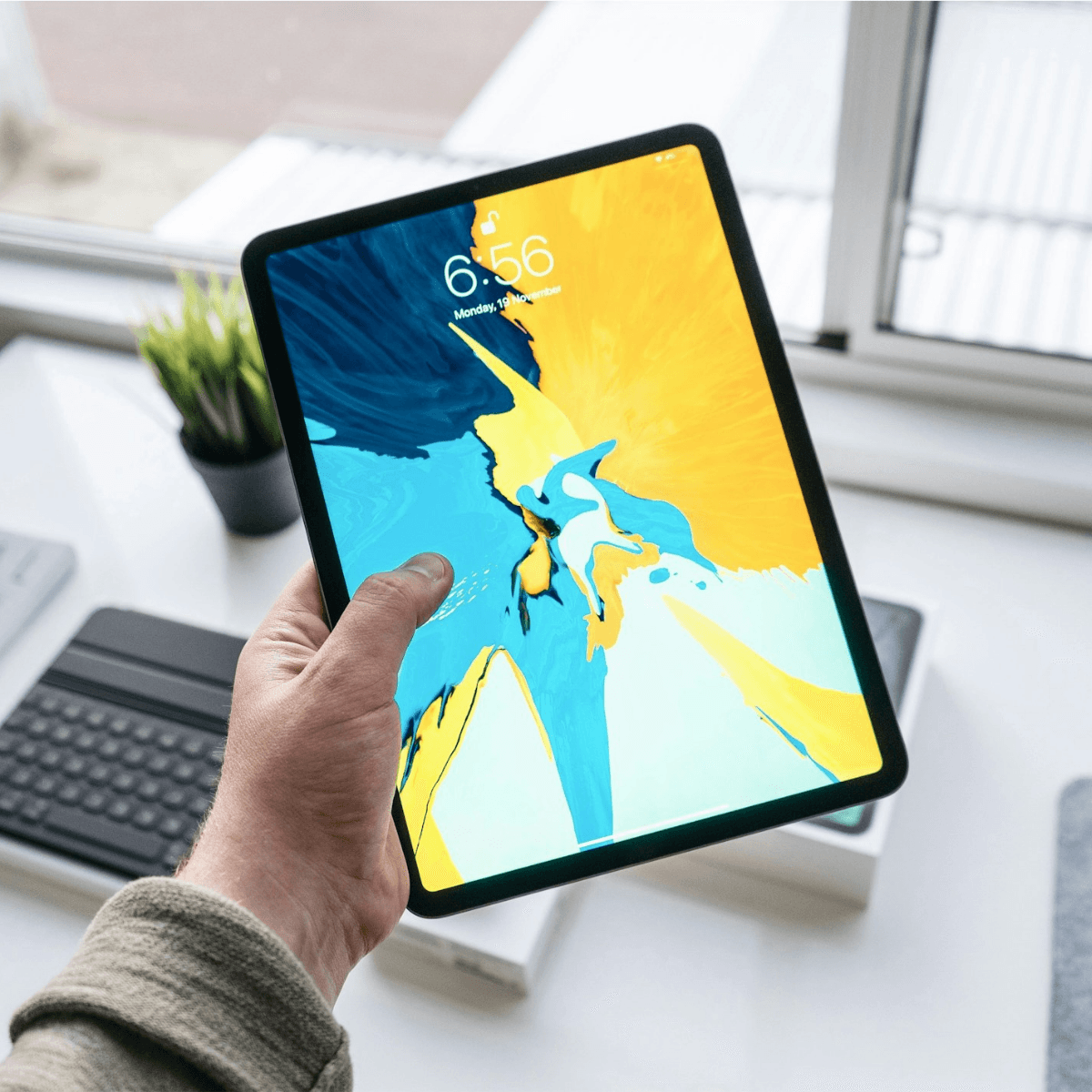 a hand holding an ipad