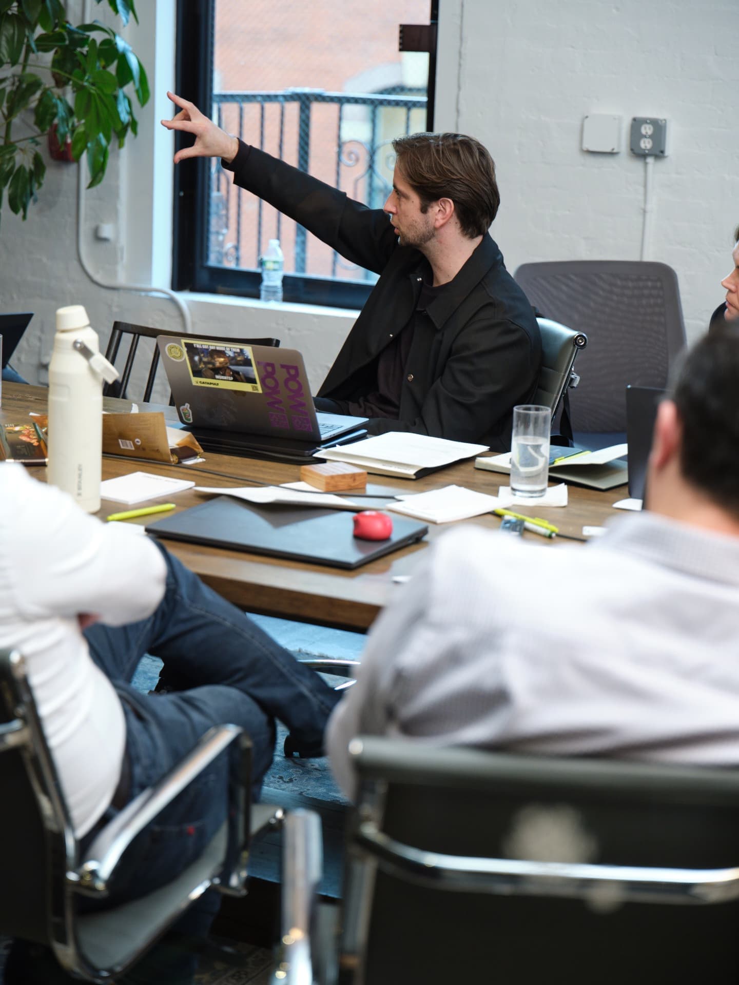 Man points to the screen during a meeting in a conference room