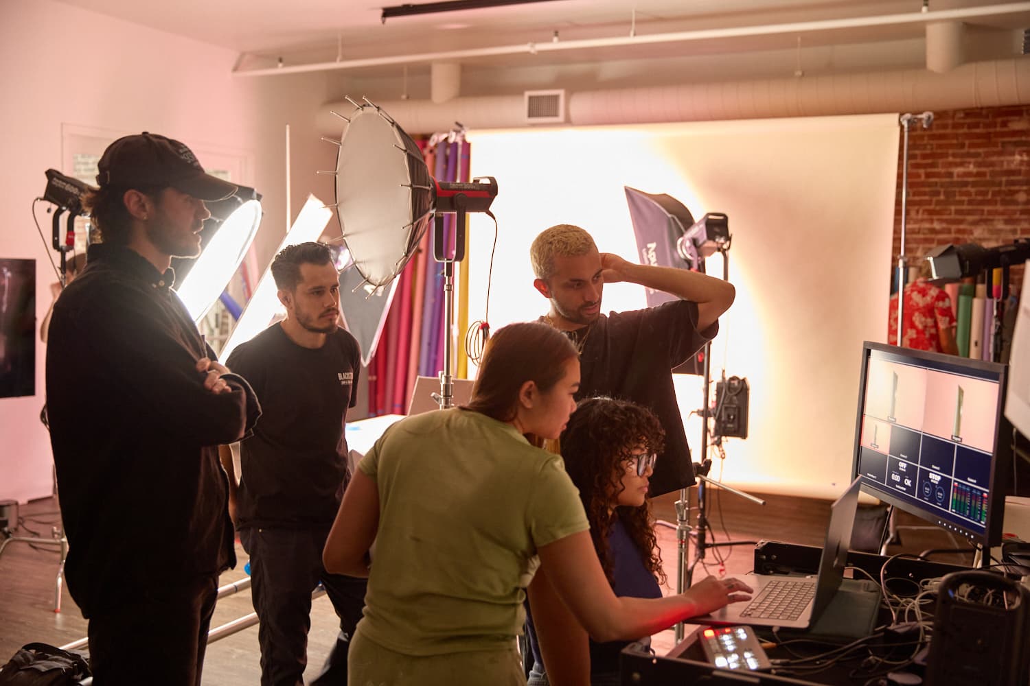 production team around a computer checking levels before a content shoot