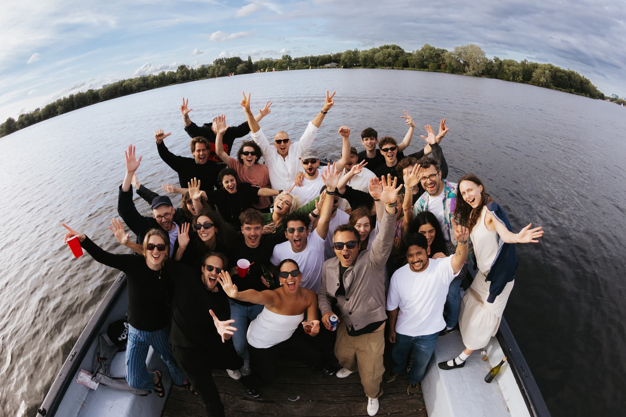 BiA team members smile at the camera on a boat overlooking a lake