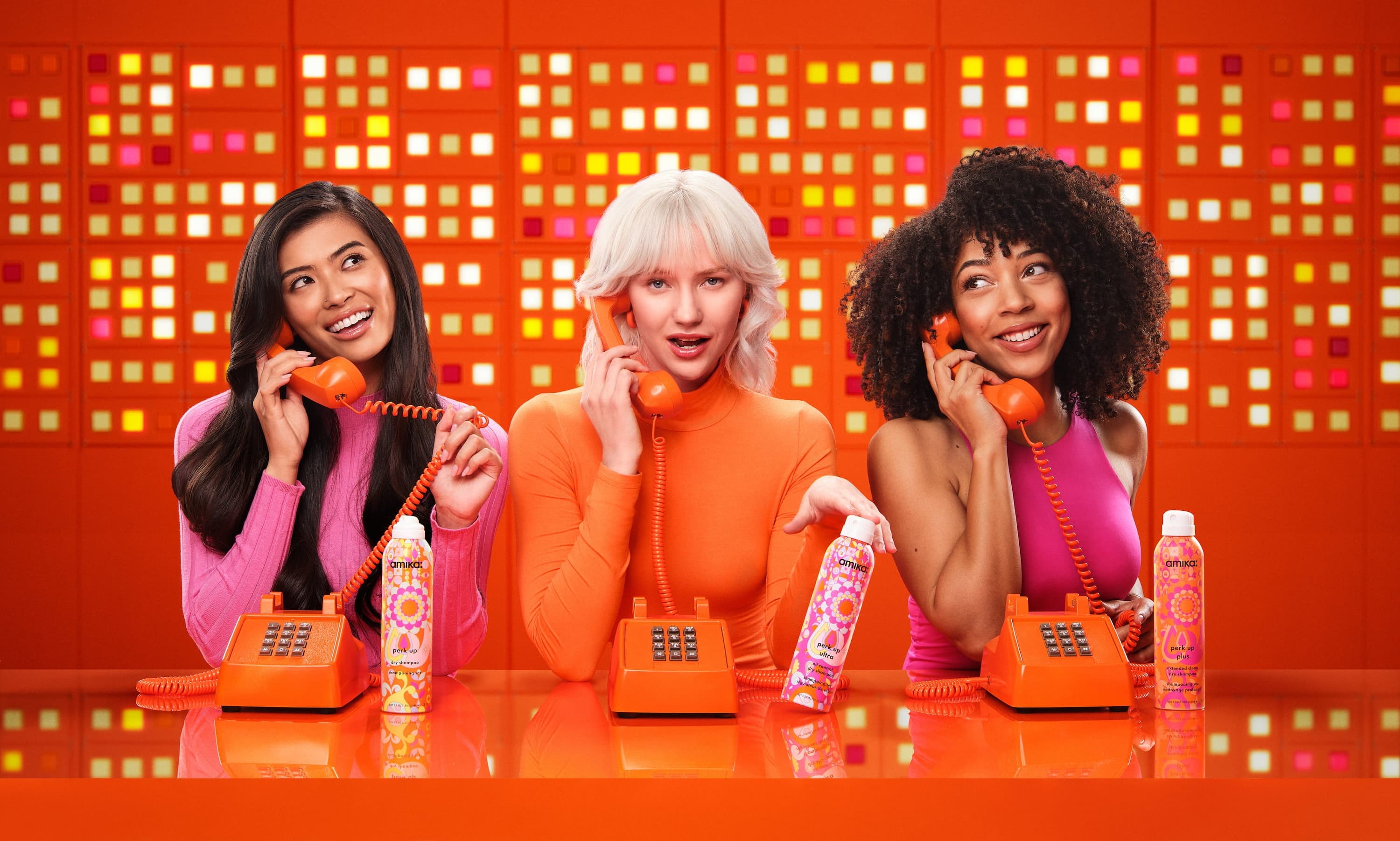 Amika campaign photography with three women holding orange phones