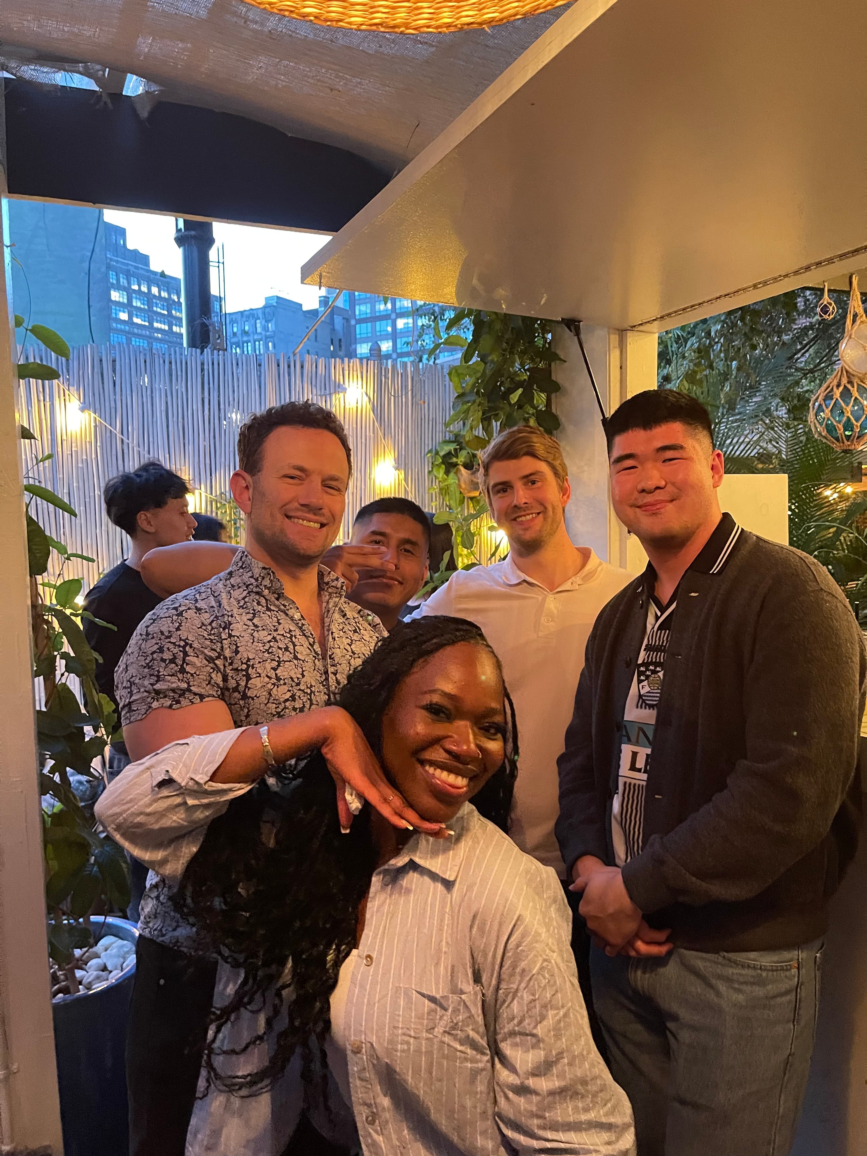 Team members pose for the camera and smile during a work happy hour