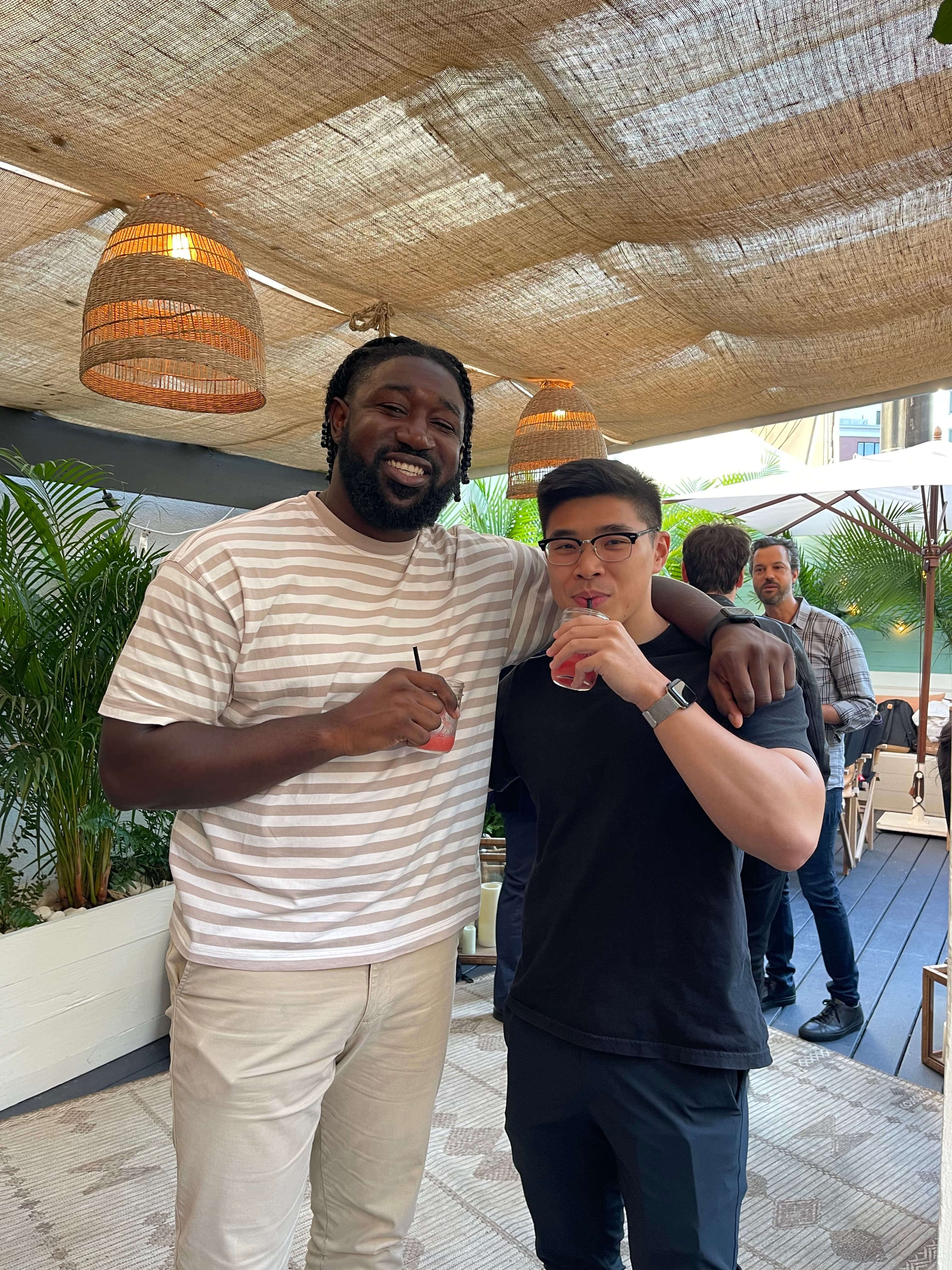 Two men smile for the camera during a work happy hour