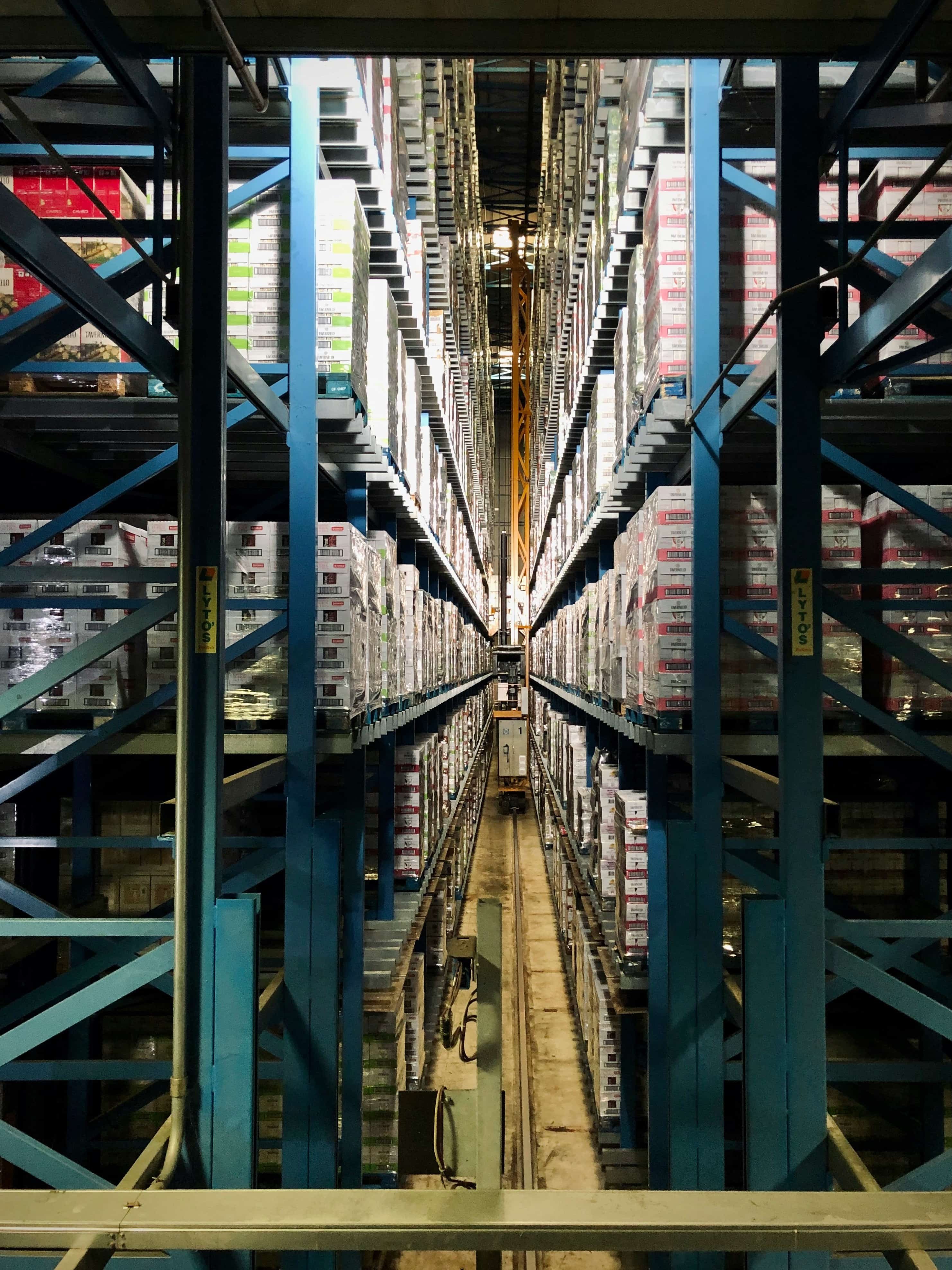 warehouse with a long hallway full of boxes and pallets